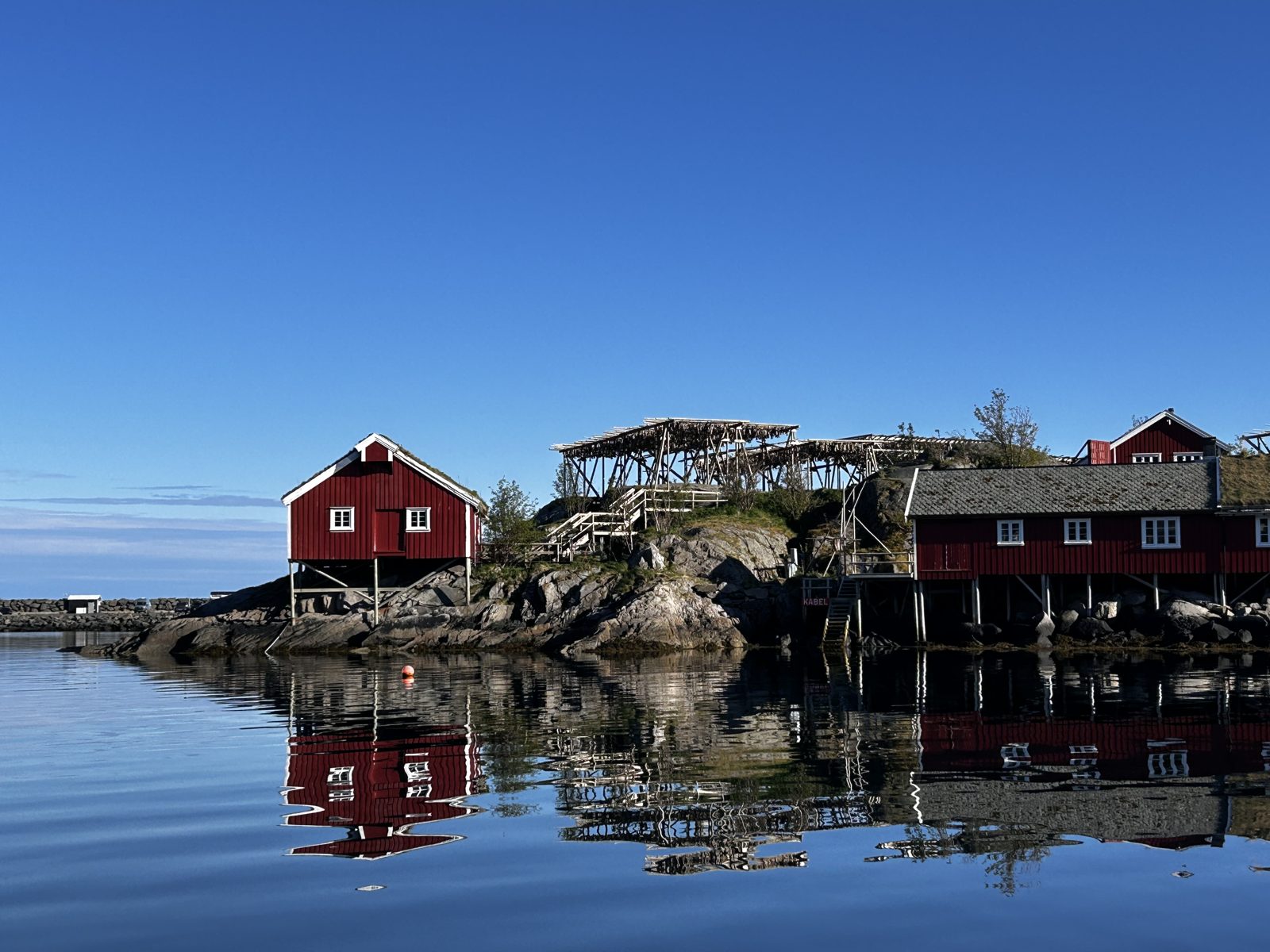 A cluster of rorbu cabins on the rocks near Sakris&oslash;y, mirrored