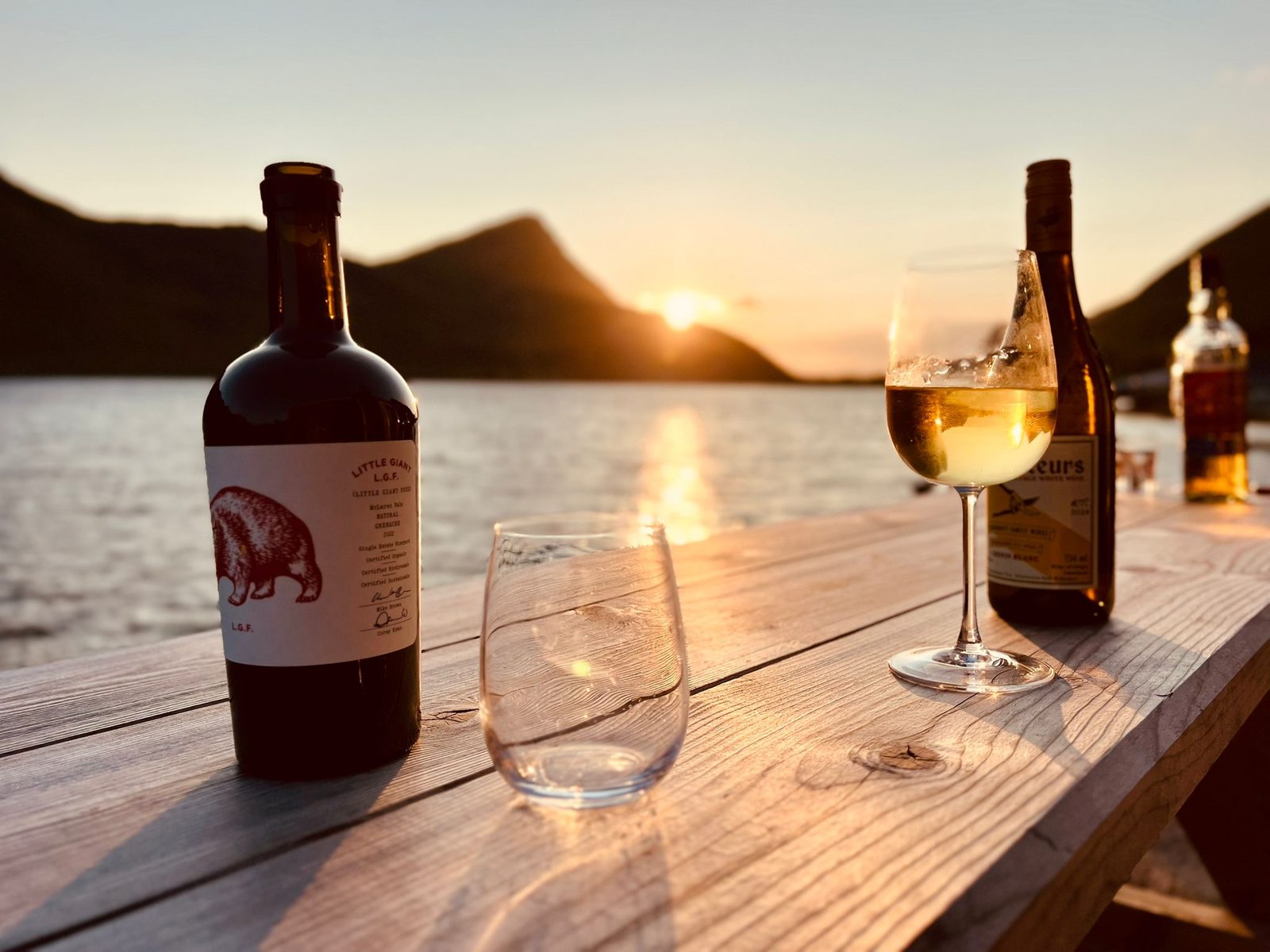 Dinner on the dock, late on a summer night, the midnight sun behind.