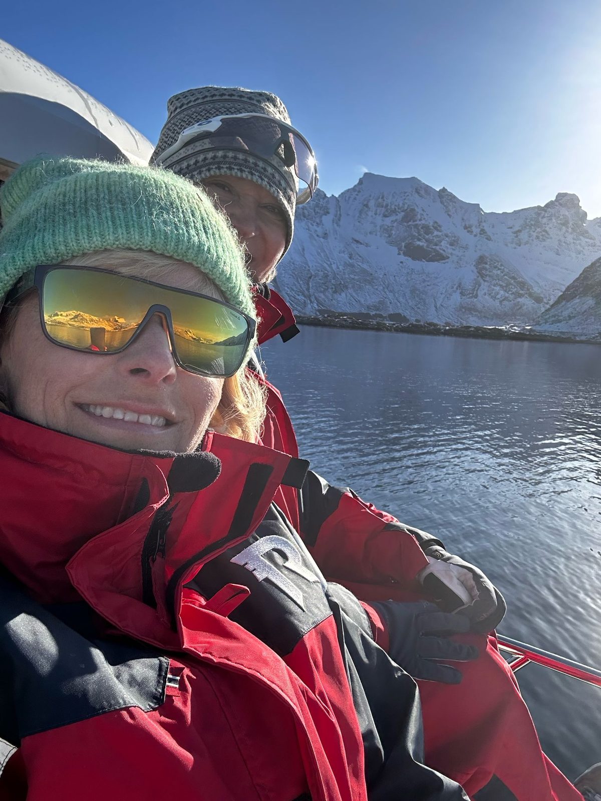 Vegard and Susanne out on the winter fjord, low sun and snow on the peaks.