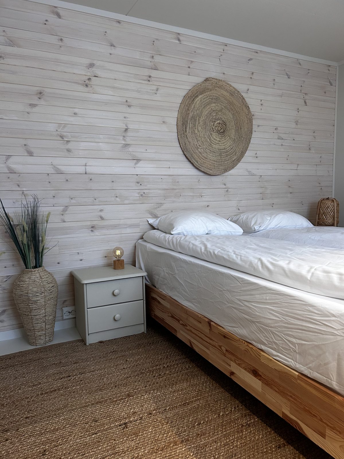 Bedroom with a queen bed and panelled wall. Photo 5 of 7.
