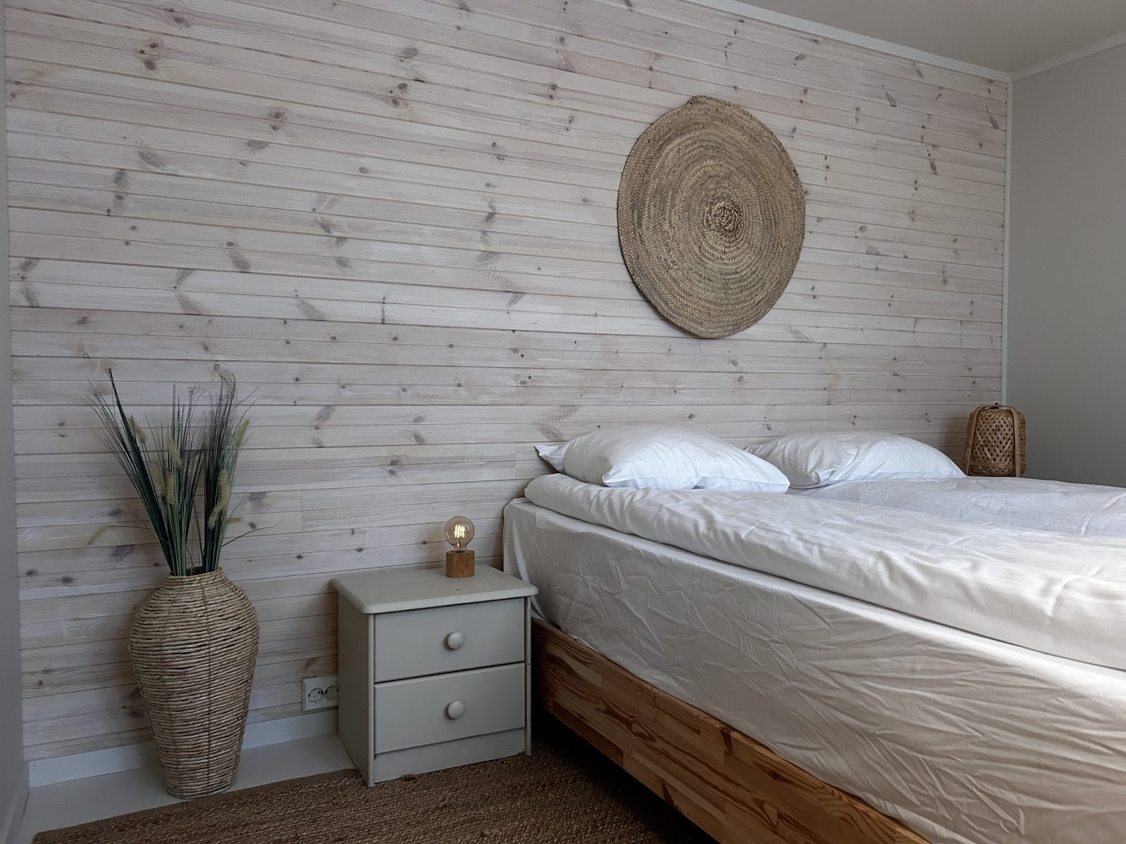 Bedroom with a queen bed and panelled wall. Photo 6 of 7.