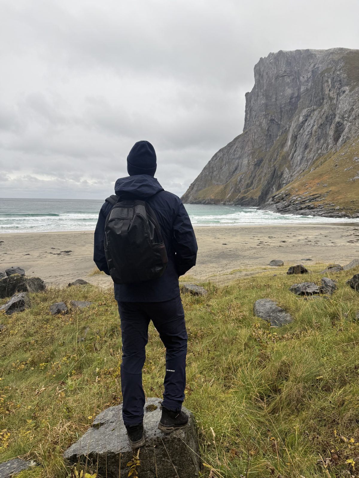 Standing on the sand at Kvalvika under the cliffs