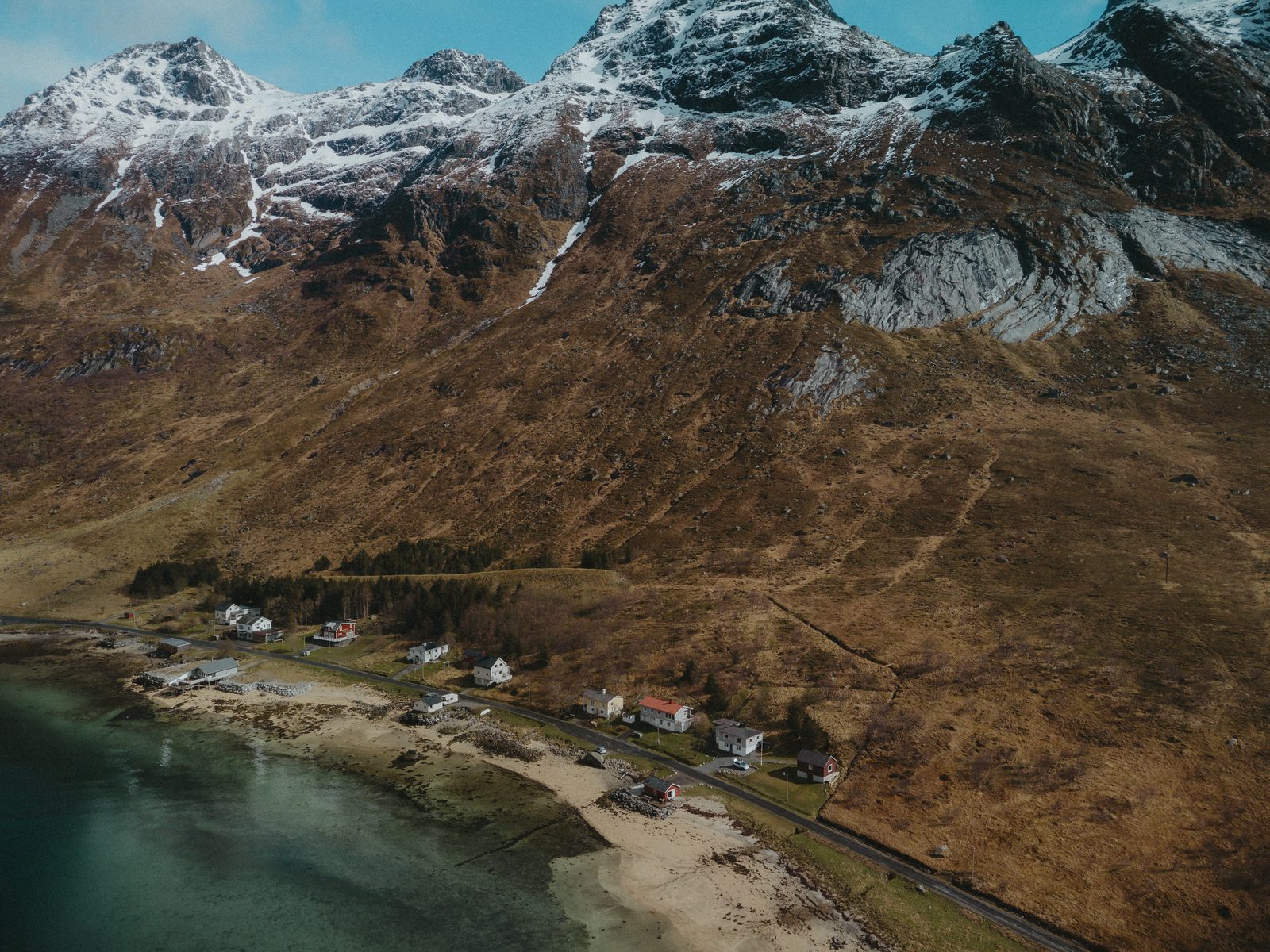 The property from above: three buildings, the beach, and the fjord.