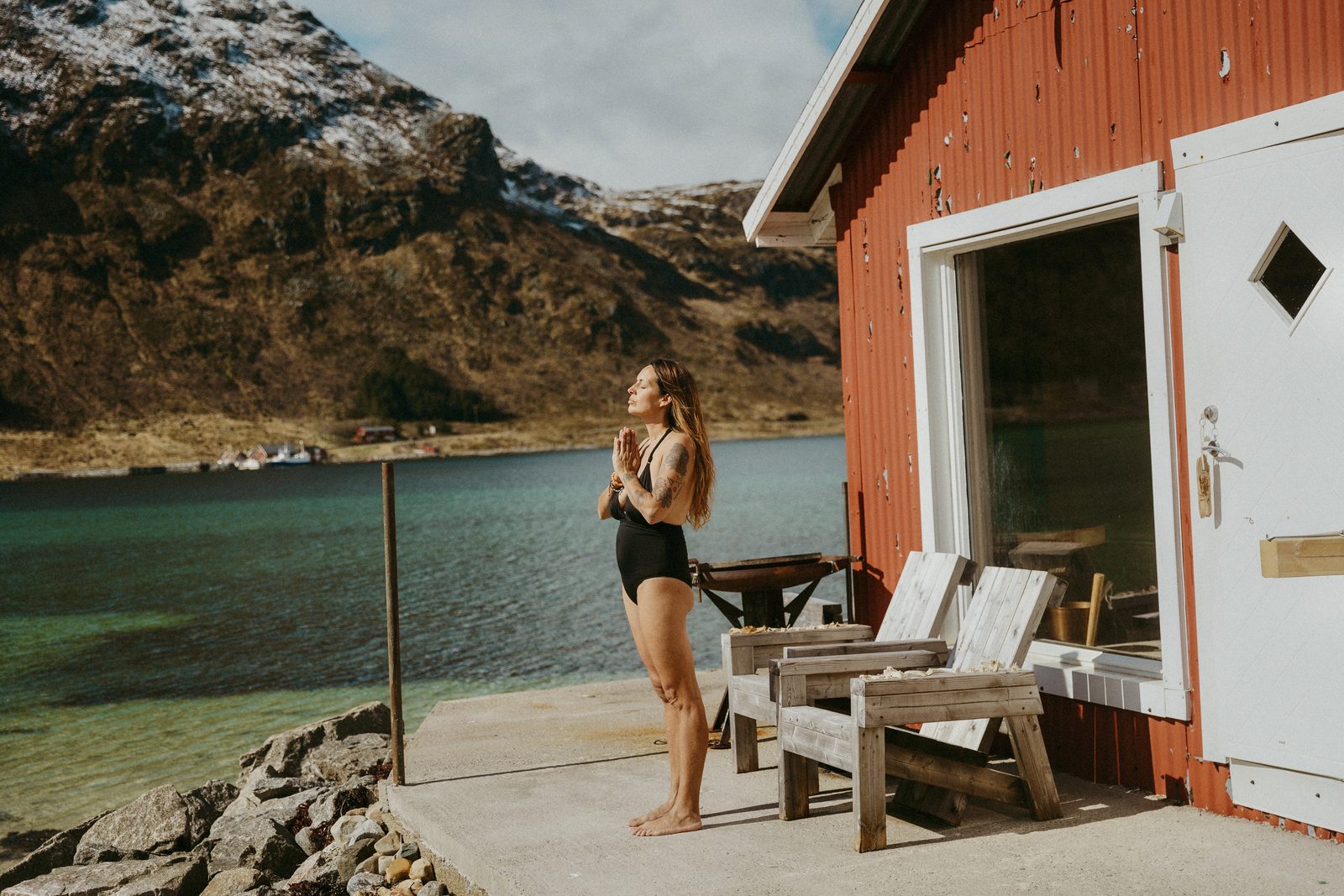The red boathouse sauna at the water's edge.
