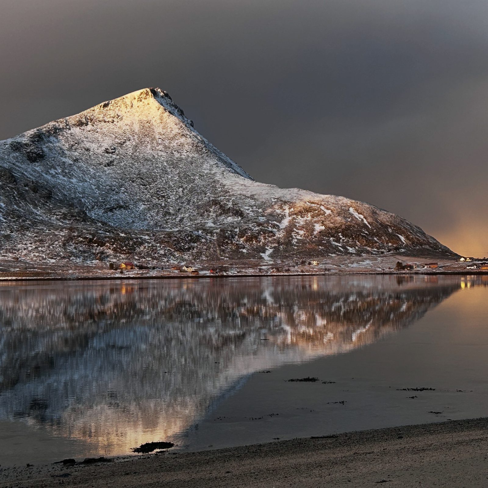 Volandstind in low winter sun, mirrored in the fjord.