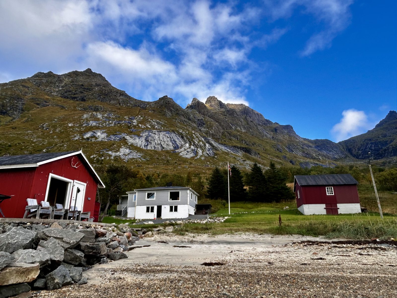 The whole property in summer, from the fjord.