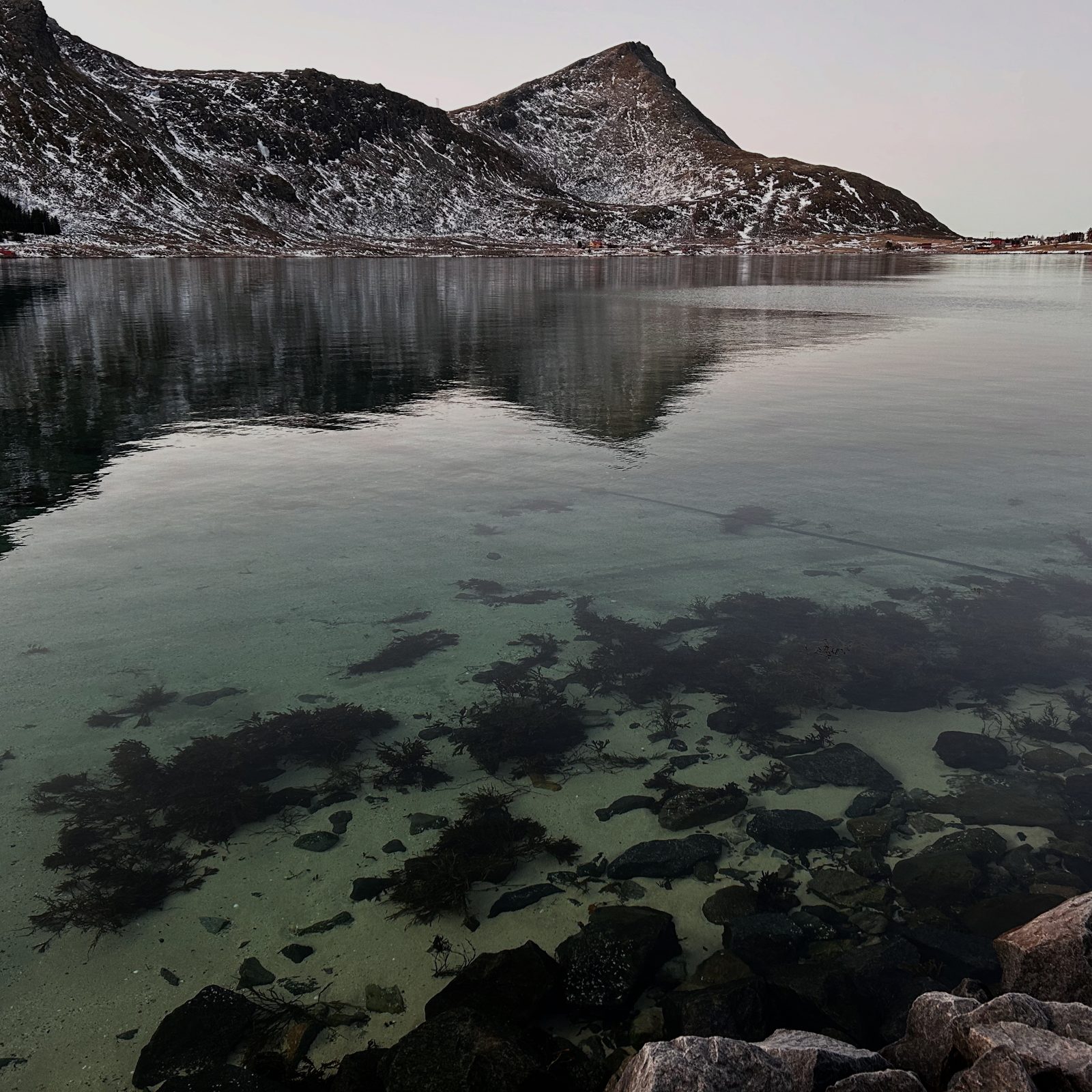Clear shallow water in front of the dock in winter light.