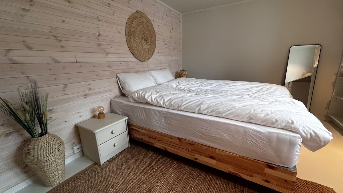 Bedroom with a queen bed and panelled wall. Photo 1 of 7.