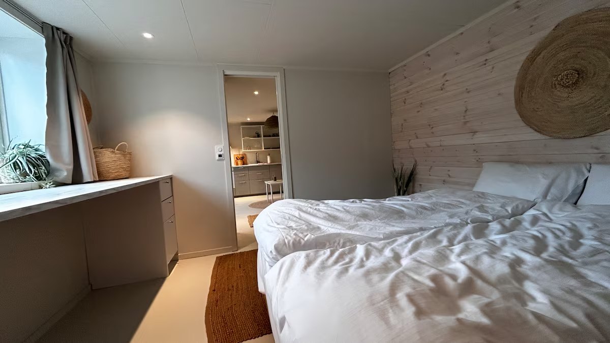 Bedroom with a queen bed and panelled wall. Photo 2 of 7.