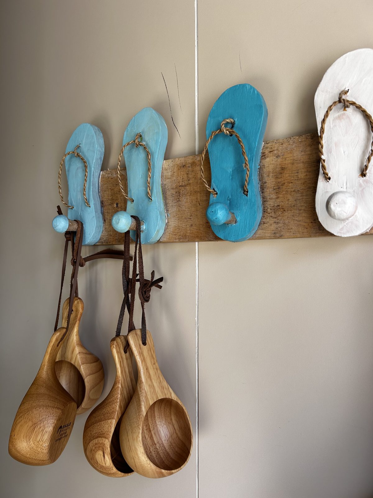 Wooden cups and hooks on the sauna wall.