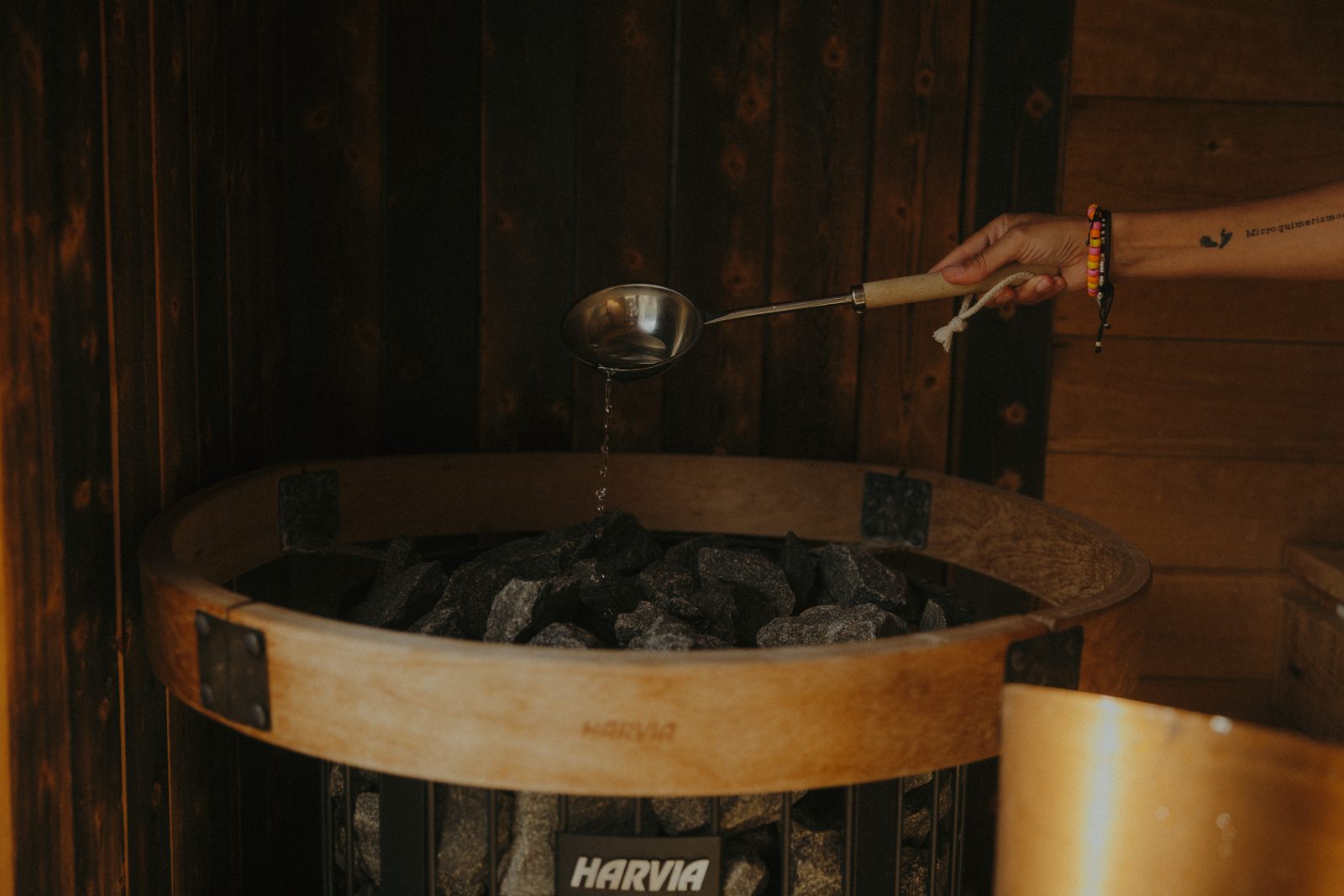 A ladle of water poured over the heater rocks.